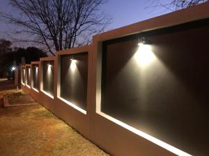una fila de vallas con luces encendidas por la noche en Genie's Nest Ooie 2 en Pretoria