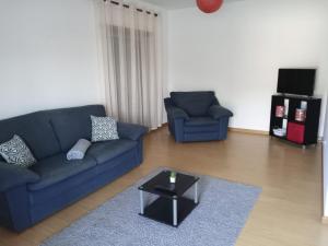ein Wohnzimmer mit einem blauen Sofa und einem Couchtisch in der Unterkunft Sao Martinho Place in São Martinho do Porto
