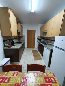 eine Küche mit einem Tisch und einem weißen Kühlschrank in der Unterkunft Sao Martinho Place in São Martinho do Porto