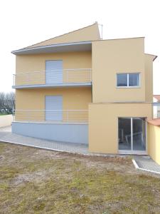 Großes gelbes Haus mit Balkon in der Unterkunft Sao Martinho Place in São Martinho do Porto