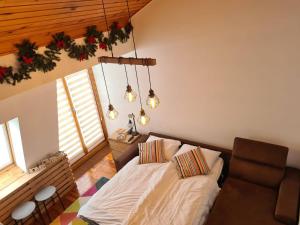 a bedroom with a bed and a couch and lights at Private Apartment Farra - Aparthotel Vučko in Jahorina