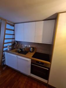 a kitchen with white cabinets and a sink and a stove at Aparthotel Vučko Apartment Farra in Jahorina