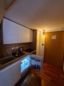 a small kitchen with an open refrigerator in the floor at Aparthotel Vučko Apartment Farra in Jahorina