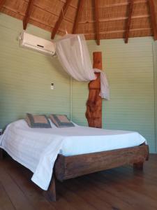 a bedroom with a bed with a white comforter at Yulelé Cabañas in Punta Del Diablo