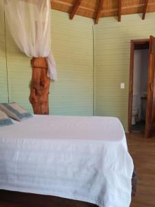 a bedroom with a white bed in a room at Yulelé Cabañas in Punta Del Diablo
