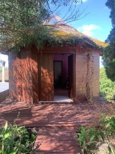 a small building with a grass roof at Yulelé Cabañas in Punta Del Diablo