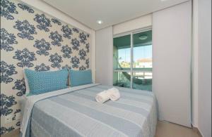 a bedroom with a bed with two rolled towels on it at Condomínio Villas do Atlântico in Porto De Galinhas