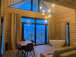 a bathroom with a room with a tub and a table at Magura Resort in Yablunytsya