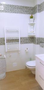 a white bathroom with a toilet and a window at Ocean View - Fantástico Studio em Albufeira in Albufeira
