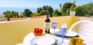 a table with a bottle of wine and glasses on a balcony at Ocean View - Fantástico Studio em Albufeira in Albufeira