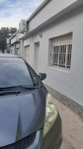 a car parked in front of a white building at Q255 - Dpto PB zona residencial en Neuquen in Neuquén