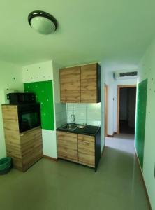 a kitchen with wooden cabinets and a black counter top at Apartments Pongrac in Cres
