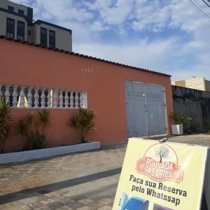 um cartaz em frente a um edifício com uma janela de pizza em Pousada das Artes 2 em Mongaguá