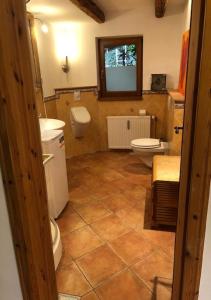 a bathroom with two toilets and a tv on the wall at Top Apartment 3 in Rosengarten/Hamburg in Rosengarten