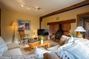 a living room with a couch and a fireplace at Pounce Hall -Stunning historic home in rural Essex in Saffron Walden