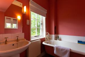 a bathroom with a sink and a tub and a window at Pounce Hall -Stunning historic home in rural Essex in Saffron Walden +37 photos