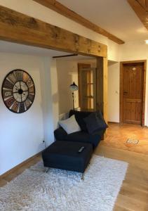 a living room with a couch and a clock on the wall at Top Apartment 3 in Rosengarten/Hamburg in Rosengarten