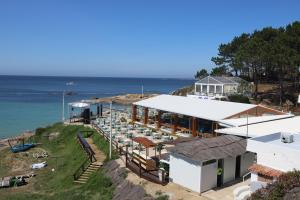 an aerial view of a building with the ocean behind it at Casa Vazquez Sanxenxo La Lanzada in O Grove