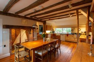 una cucina e una sala da pranzo con tavolo e sedie in legno di Pounce Hall -Stunning historic home in rural Essex a Saffron Walden