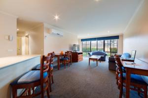 a living room with a bar and a dining room at Canberra Parklands Central Apartment Hotel Official in Canberra +36 photos