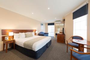 a hotel room with a bed and a desk and chair at Best Western Plus Canberra Central Apartments Official in Canberra +34 photos