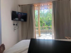 TV colgada en una pared junto a una ventana en Casa de ferias, en Trancoso