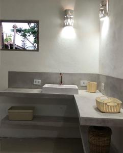 Un baño con un lavabo blanco y un espejo. en Casa de ferias, en Trancoso