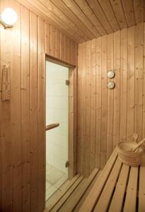a wooden bathroom with a shower and a tub at Pippi´s Ostseetraum in Sierksdorf