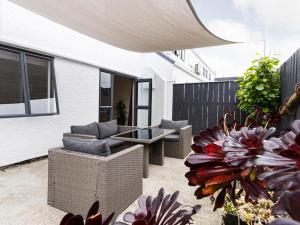 een patio met stoelen, een tafel en bloemen bij Drovers Motor Inn in Palmerston North