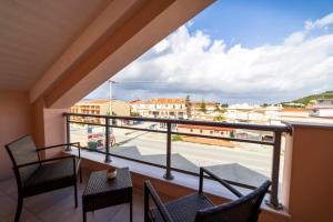 a balcony with chairs and a view of a street at Gold Olive Suites in Alikanas