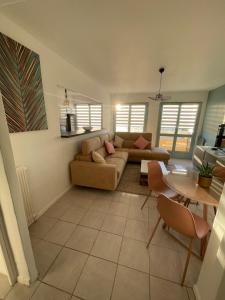 弗雷瑞斯Frejus Plage - 50m2 au calme, tout à pieds的客厅里有一张沙发和一张桌子。 更多29张照片