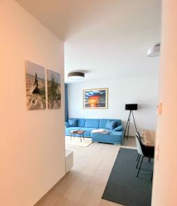 ein Wohnzimmer mit einer blauen Couch und einem Tisch in der Unterkunft Fewo unweit Warnemünde Sobierajczyk in Markgrafenheide in Rostock