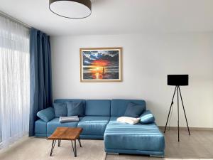 ein Wohnzimmer mit einer blauen Couch und einem Tisch in der Unterkunft Fewo unweit Warnemünde Sobierajczyk in Markgrafenheide in Rostock