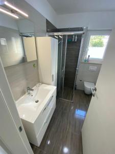 a bathroom with a white sink and a shower at Apartment Lola in Srima +25 photos