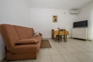a living room with a couch and a table at Apartment in Lopar with Terrace, Air conditioning, Wi-Fi (4612-3) in Lopar