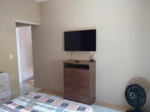 een woonkamer met een flatscreen-tv aan de muur bij Chalé Boa Vista in Ilhabela