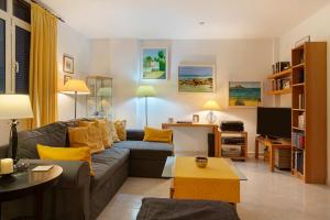 een woonkamer met een grijze bank en gele kussens bij Vcv Villa Magua in Santa Brígida