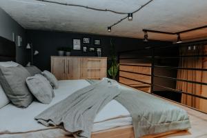 a bedroom with a bed with a blanket on it at Apartament Loft z Antresolami in Zamość