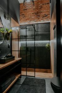 a bathroom with a shower with a glass door at Apartament Loft z Antresolami in Zamość +39 photos