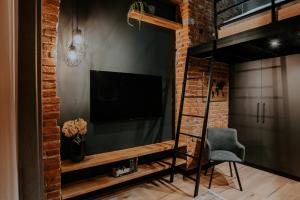 Televízia a/alebo spoločenská miestnosť v ubytovaní Apartament Loft z Antresolami