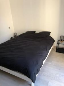 - un lit avec une couette noire dans une chambre dans l'établissement Villa avec vue campagne, à Carpentras