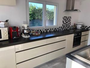 a kitchen with white cabinets and a window at Villa avec vue campagne in Carpentras