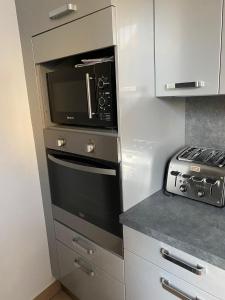 a kitchen with a microwave and a stove at Grand F4 de 71m2 pour 6 personnes en plein centre ville Arpajon in Arpajon