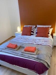 a large bed with three pillows on top of it at Grand F3 de 71m2 en plein centre ville Arpajon in Arpajon