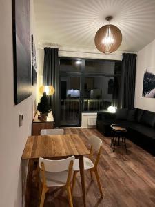 sala de estar con mesa de madera y sillas en Ubytování Zadov - Apartmán Prenet en Stachy