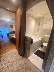 La salle de bains est pourvue d'une baignoire, d'un lavabo et de toilettes. dans l'établissement Apartment im Stadtzentrum mit W-LAN und Netflix Home Sweet Home, à Fürth