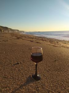 a glass of wine sitting on the beach at Katsenos studios in Nikiana