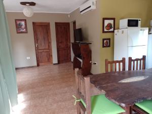 Una cocina con una mesa y un refrigerador blanco. en Cerro Encanto, en Potrero de los Funes