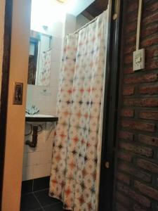 a bathroom with a shower curtain with a sink at Las Adelas Chaltén in El Chalten