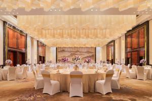 um grande salão de banquetes com uma mesa longa e cadeiras em Wanda Realm Nanchang em Nanchang